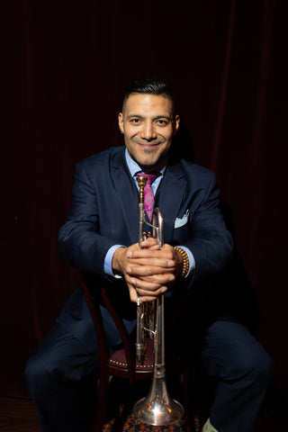 Victor Garcia, jazz trumpeter, seated holding his trumpet